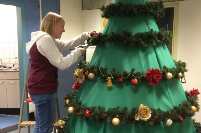 Chantal in actie in het PRIMA Atelier, bezig met het creëren van de betoverende kerstbomen-op-stelten kostuums, elk sprankelend detail met zorg vervaardigend